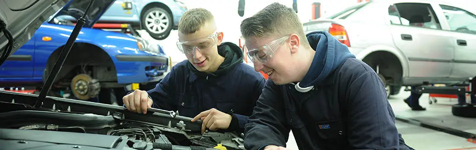 Motor vehicle students looking at car engine